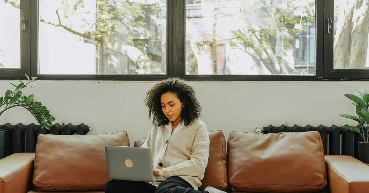 Writer sitting on couch with laptop