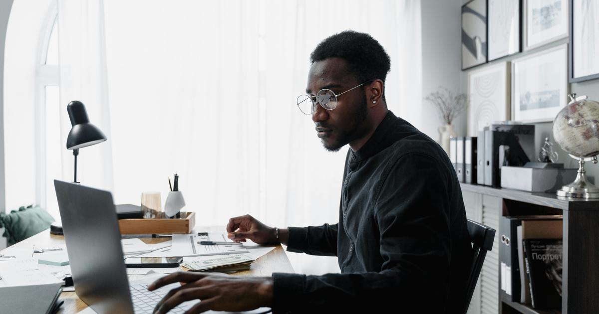 Writer sitting at desk typing on laptop